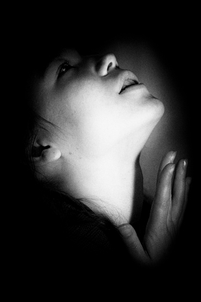 woman in shadows praying