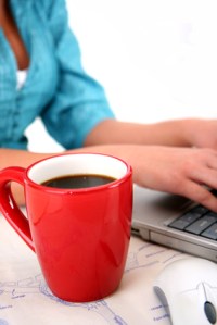 woman typing with coffee