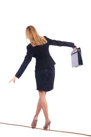 Business woman balancing on tightrope