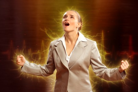 Woman with clinched fist, looking up, filled with emotion