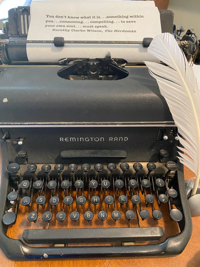 Old typewriter with paper containing quote: "You don't know what it is . . . something within you. . .consuming. . .compelling . . . to save your own soul. . . must speak. from The Herdsman by Dorothy Clarke Wilson
